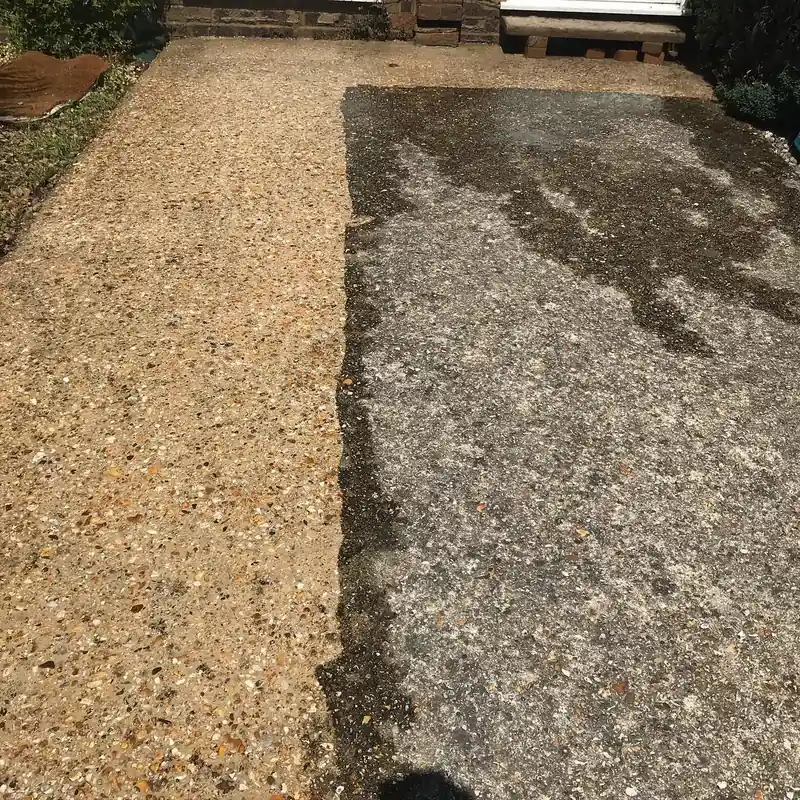 An aggregate path with one side cleaned and the other still dark with dirt